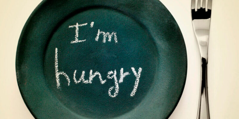 A stock of an empty plate and a fork with the sign, "I'm Hungry."