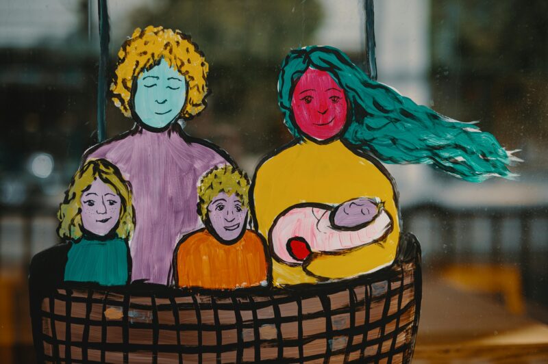 An illustration of a family with two children and a baby standing in a basket.