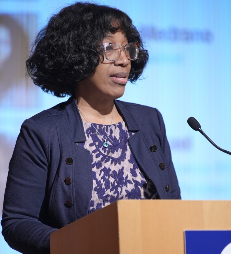 kelley raphael standing behind a speaker stand