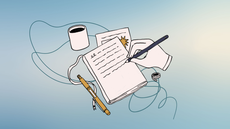 a hand is holding a pen and is writing in a notebook